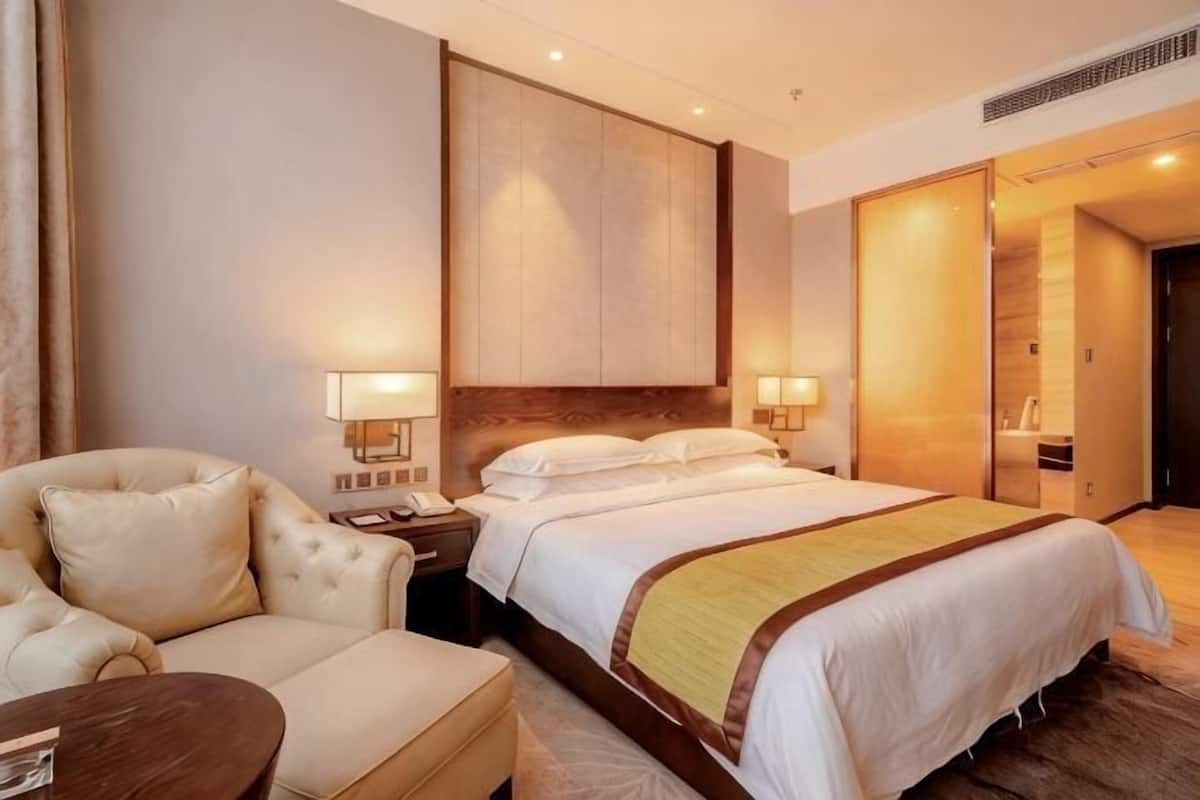 Ein Hotelzimmer mit einem Bett, einem Schlafsofa, einem Nachttisch und einem Spiegel.