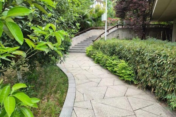 Un sendero de piedra que asciende por una escalera rodeada de abundante vegetación.
