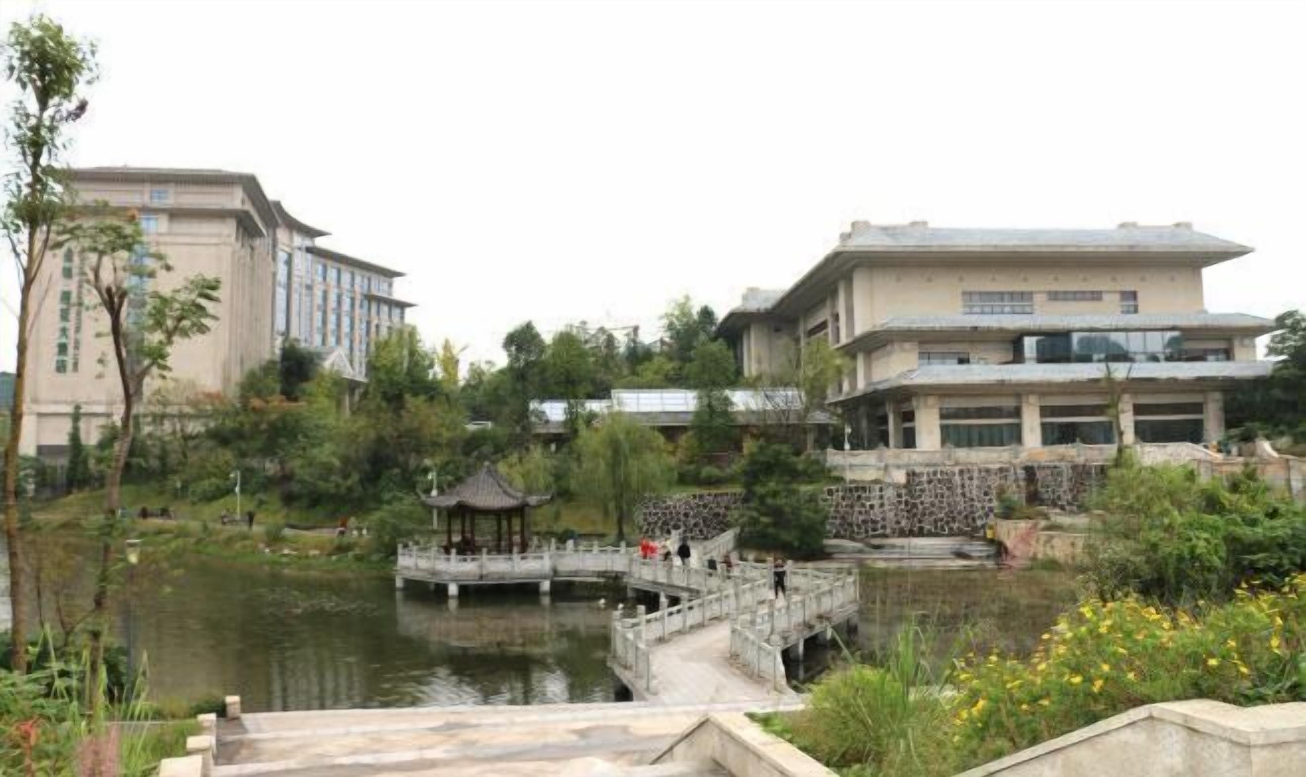 A traditional Chinese-style building with a garden, a pond, and a bridge.
