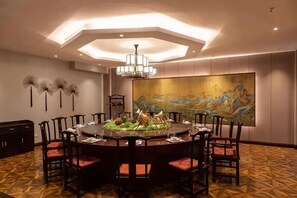 A dining area with a round table, chairs, and a central decorative piece. - Yoron Hotel (Nanchang County)