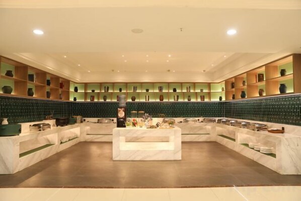 A spacious lobby with a central seating area and a wall of shelves displaying various items.