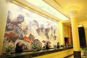 A lobby with a large traditional painting, reception desk, and potted plants. - Yoron Hotel (Nanchang County)