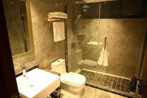 A modern bathroom with a glass-enclosed shower, a white sink, and a toilet. - Yoron Hotel (Nanchang County)