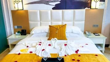 Ein Hotelzimmer mit einem großen Bett, einem Kopfteil, zwei Nachttischen und einem an der Wand hängenden Kunstwerk.