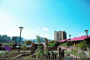 Un jardín en la azotea con vistas al horizonte urbano, que incluye edificios y un río.