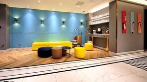 Una sala de estar moderna con un sofá amarillo, otomanas y una mesita de centro.
