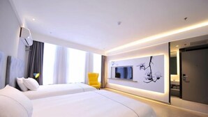 Una habitación de hotel moderna con dos camas, un ventanal con cortinas, un televisor montado en la pared y una decoración minimalista.