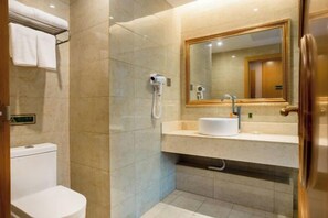 A modern bathroom with a toilet, a sink, a mirror, and a hairdryer. - Vienna Hotel (Chongqing Dazu Stone Carving) (Chongqing)