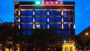 A multi-story hotel with a modern facade, illuminated signage, and a prominent entrance. - Vienna Hotel (Chongqing Dazu Stone Carving) (Chongqing)
