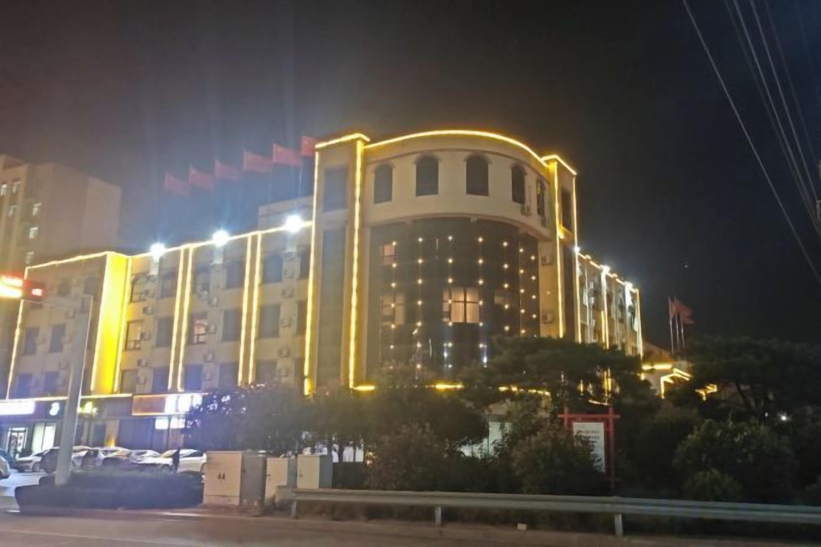 Un edifici de diverses plantes amb façana corba i finestres il·luminades de nit.