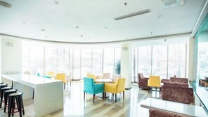 A modern hotel lobby with a central island, seating areas, and large windows. - Jucheng Youpin Hotel (Ju County)