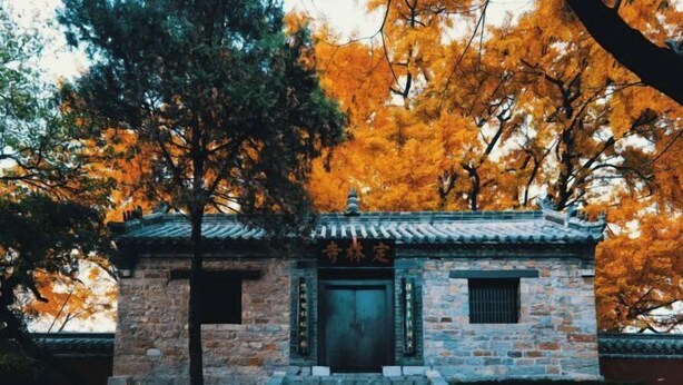 A traditional stone building with a tiled roof, a central entrance, and steps leading up to it. - Jucheng Youpin Hotel (Ju County)