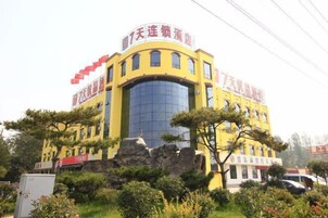 A yellow building with multiple windows and a central glass facade.