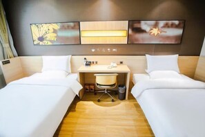 A hotel room with two beds, a desk, a chair, and a trash bin. - Jucheng Youpin Hotel (Ju County)