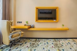 A hotel room with a desk, chair, TV, and patterned floor. - Mingcheng Boutique Hotel in Bengbu City (Bengbu)