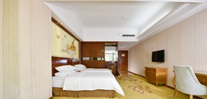 A hotel room with a large bed, a desk, a chair, a television, and a decorative wall. - Zhongtian Cultural Hotel (Jieyang Tower) (Jieyang)