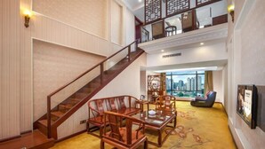 Un vestíbulo amplio con una escalera, muebles de madera y vistas a la ciudad.