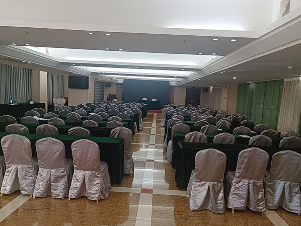 A conference room with rows of tables and chairs, a podium at the front, and a high ceiling with recessed lighting. - Zhongtian Cultural Hotel (Jieyang Tower) (Jieyang)