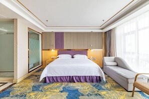 A hotel room with a large bed, a sofa, a glass shower, and a view of the city. - Foshan Star Hotel (Huili Plaza Store) (Foshan)