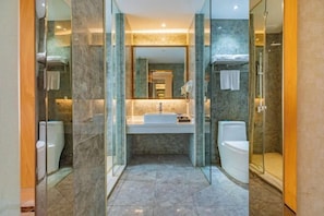 Un bagno moderno con doccia vetrata, lavandino bianco e water.