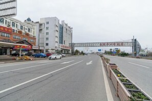 A street with buildings, a road, and a pedestrian walkway. - Rudong Victoria Hotel (Rudong)
