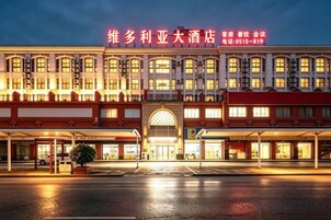 Un hotel con una entrada amplia, varios pisos y un letrero llamativo.
