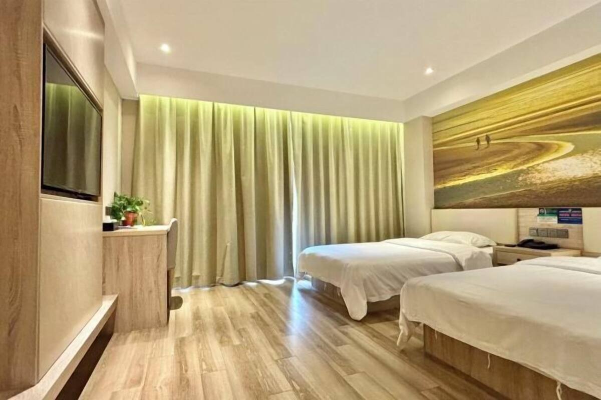 A hotel room with two beds, a large window with curtains, a flat-screen TV, and a painting on the wall.