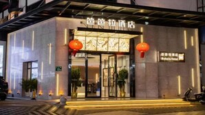 A hotel entrance with a modern design, featuring a glass door and illuminated signage. - Babala Hotel (Guangzhou Dagang) (Guangzhou)