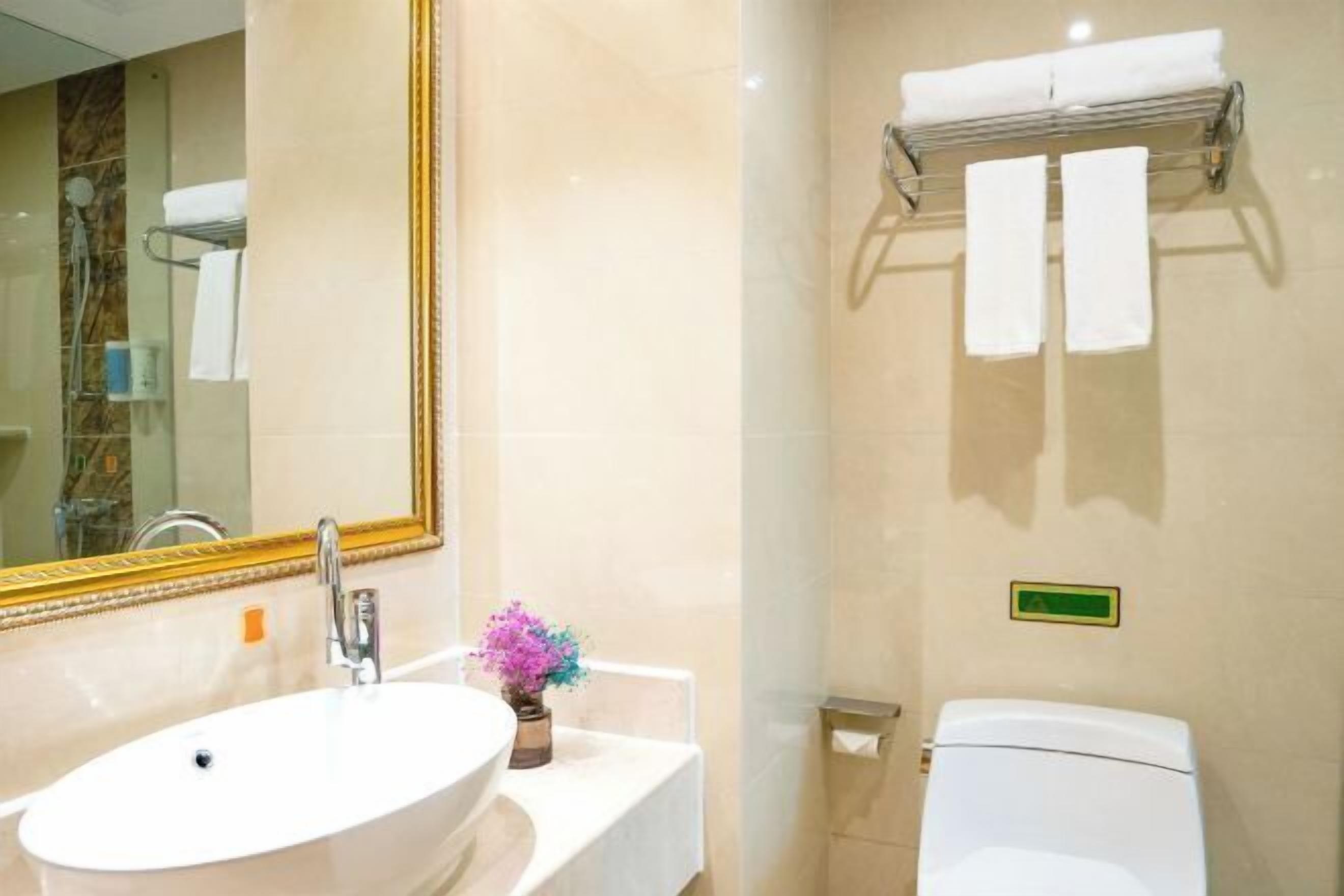 Un baño con lavamanos, espejo e inodoro.