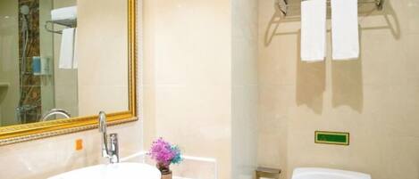 Un baño con lavamanos, espejo e inodoro.
