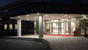 A hotel entrance with a glass door, a red carpet, and a well-lit interior. - Xunwu Hotel (Xunwu)