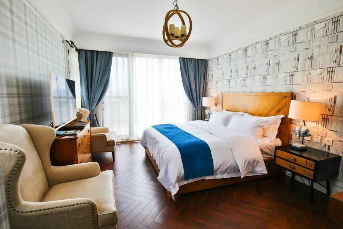 Una habitación de hotel con una cama grande, un escritorio, una silla y un televisor.