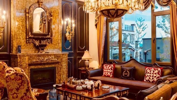 Quarto luxuoso com lareira, mobiliário requintado e uma janela grande com vista.