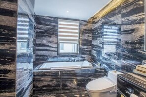 A modern bathroom with a bathtub, toilet, and vanity. - U-house Villa Hotel (Anning)