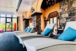 A spa area with lounge chairs and stone walls. - U-house Villa Hotel (Anning)