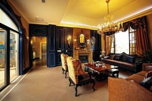 A spacious living room with a fireplace, a chandelier, and a sofa. - U-house Villa Hotel (Anning)