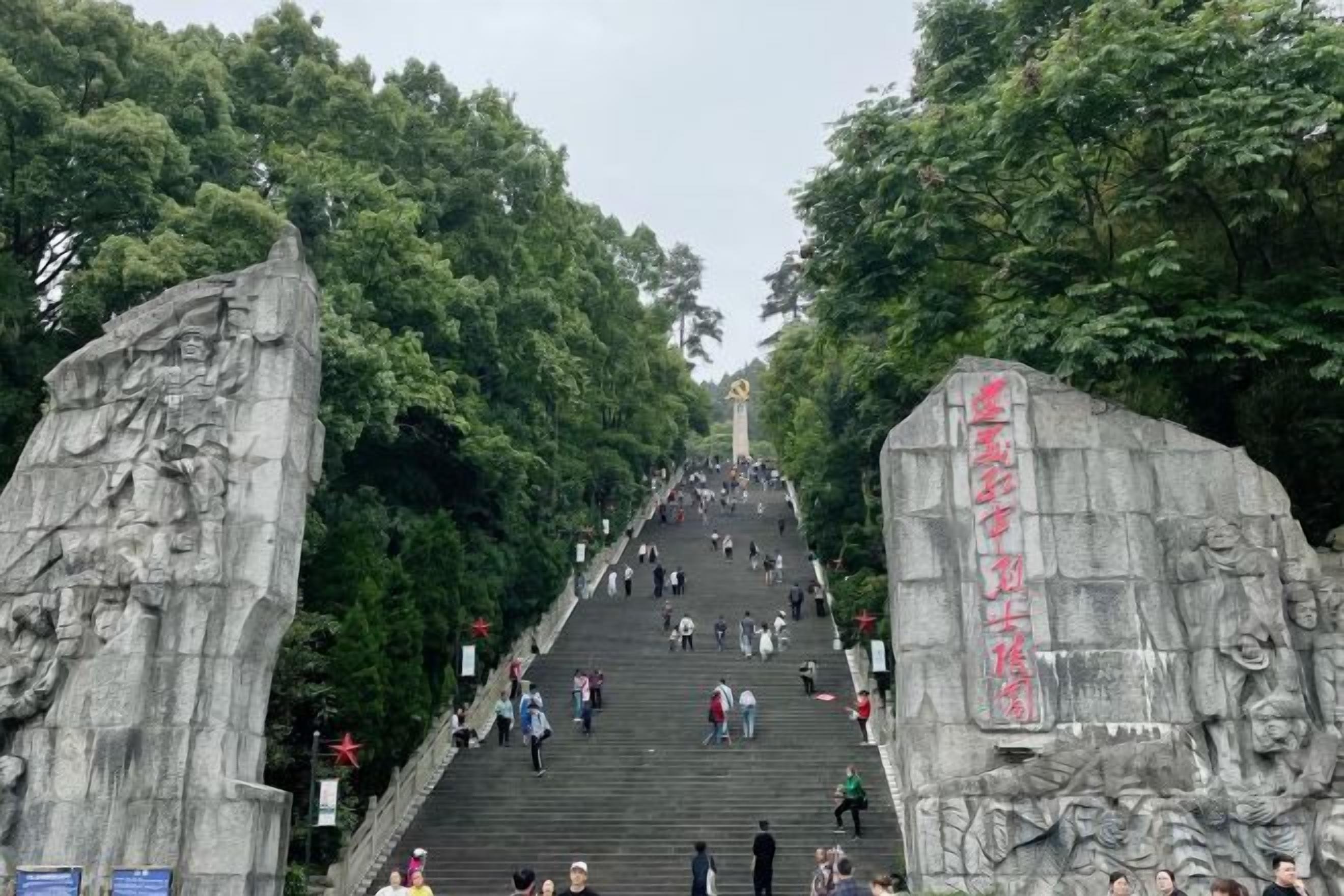 A large stone staircase leading up to a monument, surrounded by trees.
