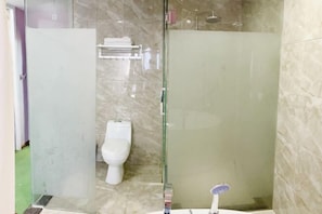 A bathroom with a glass-enclosed shower, a toilet, and a sink with a faucet. - Biyun Lanting Hotel (Zunyi Huizhi) (Zunyi)