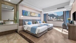 Una habitación de hotel moderna con una cama grande, un escritorio, un baño con espejo y vista a la ciudad.