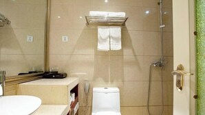 A bathroom with a toilet, a sink, a shower, and a towel rack.