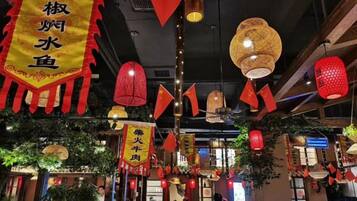 A restaurant interior with hanging red lanterns and yellow banners.