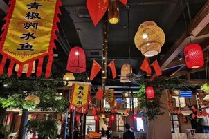 A restaurant interior with hanging red lanterns and yellow banners.