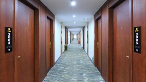 A long hallway with wooden doors, each marked with a number. - XingheHotel (Chenzhou)