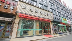 A row of storefronts with glass fronts and signage, indicating a commercial area. - Shaoxing Narnia Garden Hotel (Shaoxing)