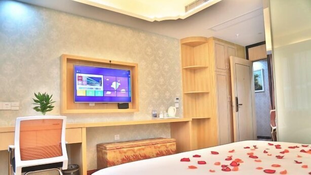 A hotel room with a bed, a desk, a TV, and a wardrobe. - Shaoxing Narnia Garden Hotel (Shaoxing)