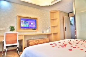 A hotel room with a bed, a desk, a TV, and a wardrobe. - Shaoxing Narnia Garden Hotel (Shaoxing)
