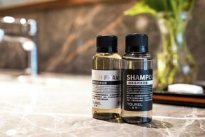 Dos botellas de productos para el cabello sobre una encimera de mármol.
