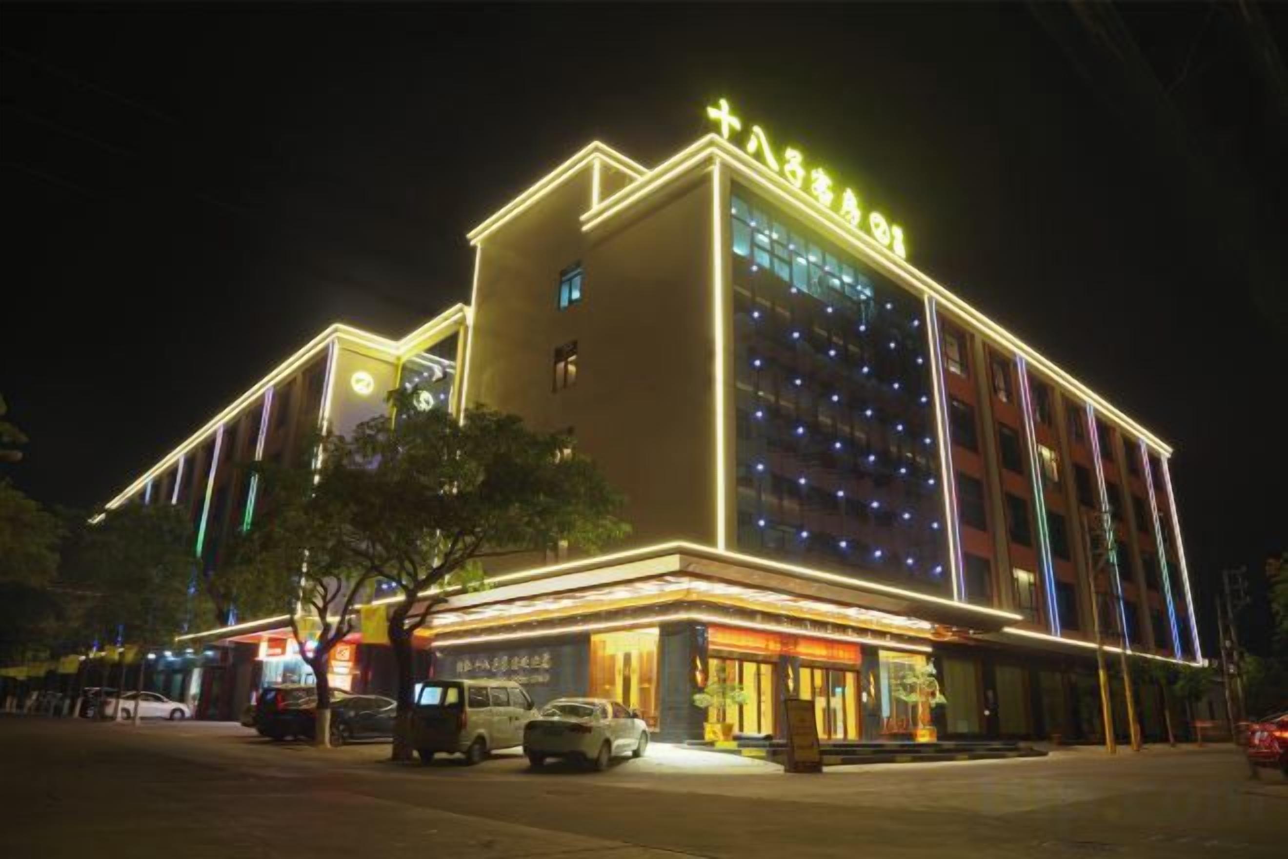 A hotel with a prominent sign, multiple floors, and a well-lit facade.