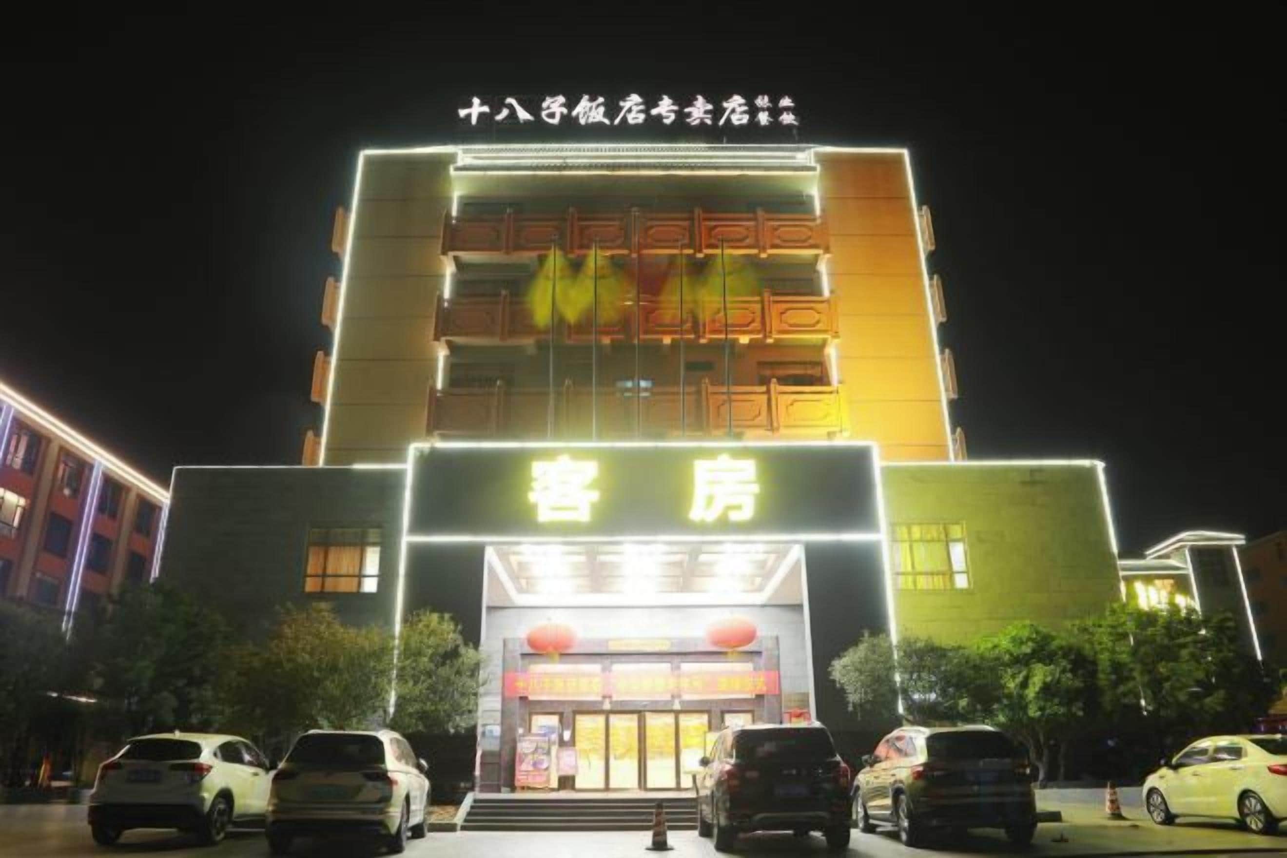 A hotel with a prominent entrance, multiple floors, and a well-lit facade.