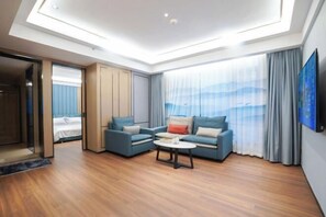 A modern hotel room with a skylight, a sofa set, a coffee table, and a large window with curtains. - Shibazi Hotel (Yangjiang)